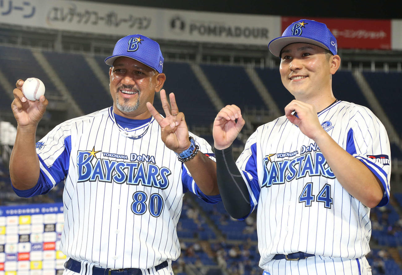 DeNA対中日　監督通算300勝を達成し、キャプテン佐野（右）と「300勝ポーズ」で写真に納まるラミレス監督（撮影・丹羽敏通）