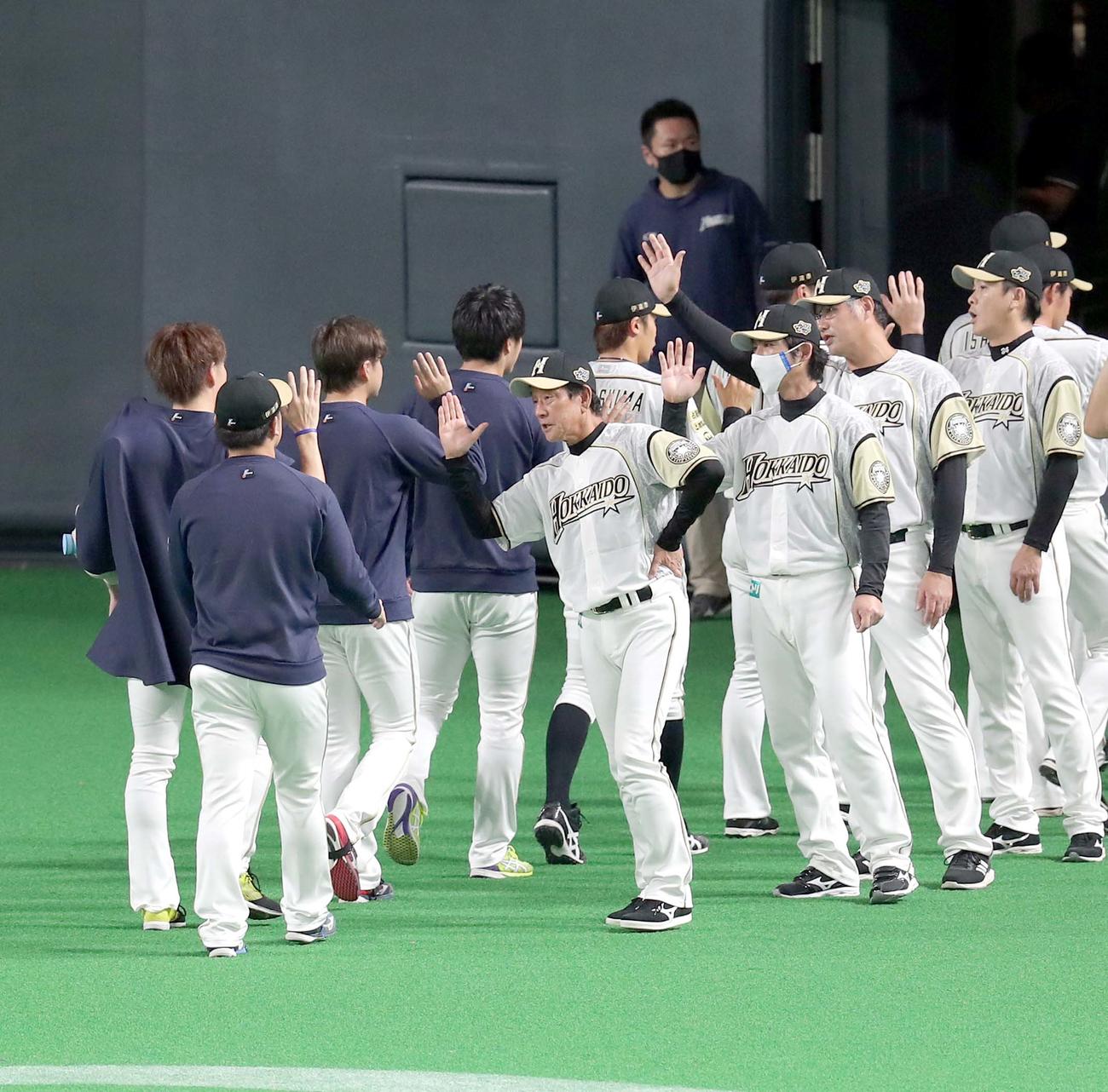 日本ハム対西武　試合終了後、日本ハム河野（左手前）を出迎える栗山監督（撮影・佐藤翔太）