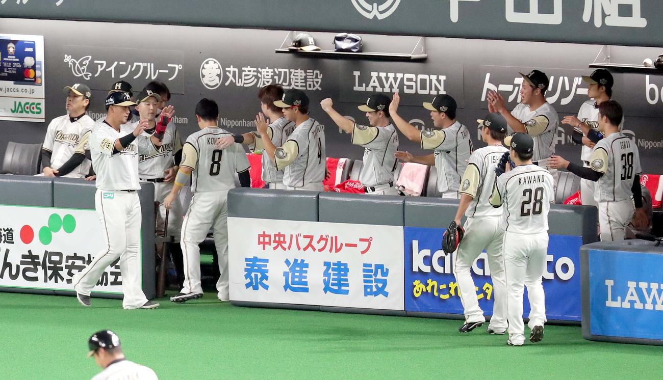 日本ハム対西武　1回裏日本ハム1死二塁、大田の適時二塁打で生還しチームメートに出迎えられる二塁走者の中田（左から2人目）（撮影・佐藤翔太）