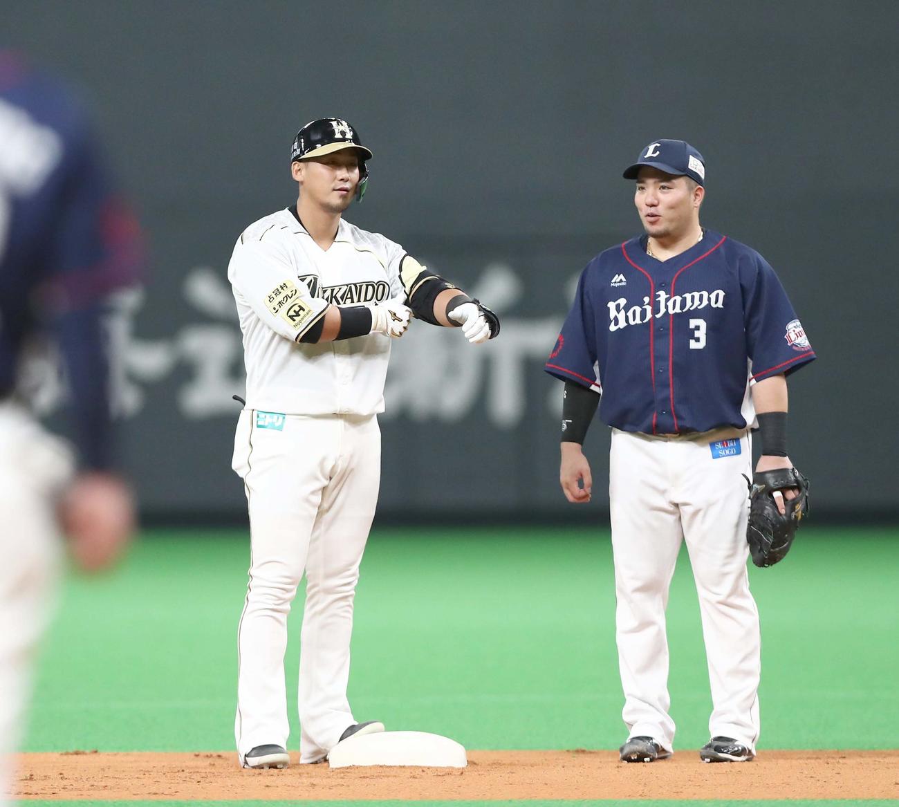 日本ハム対西武　1回裏日本ハム1死一、二塁、左越え2点適時二塁打を放つ中田（左）（撮影・黒川智章）
