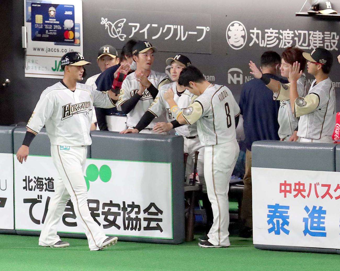 1回裏日本ハム1死二塁、大田の適時二塁打で生還し近藤（右から3人目）に出迎えられる中田（撮影・佐藤翔太）