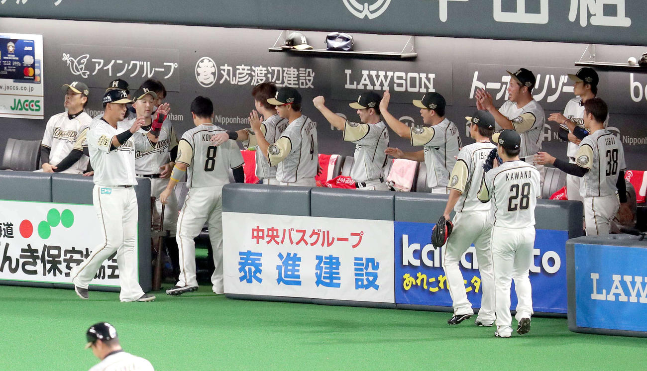 日本ハム対西武　1回裏日本ハム1死二塁、大田の適時二塁打で生還しチームメートに出迎えられる二塁走者の中田（左から2人目）（撮影・佐藤翔太）