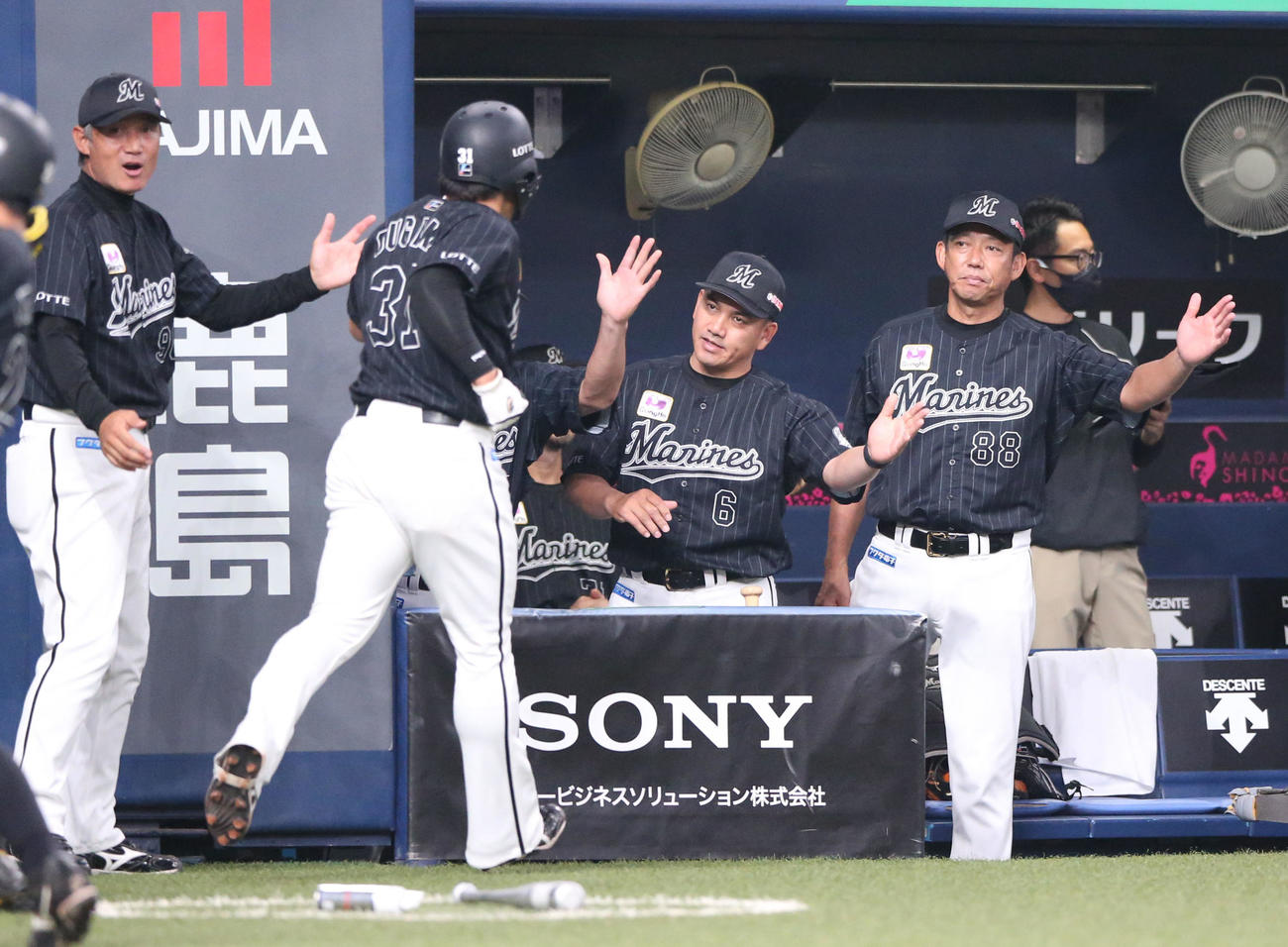 オリックス対ロッテ　2回表ロッテ1死一塁、井口監督（右から3人目）は藤岡の右中間三塁打で先制生還の菅野（手前）を出迎える（撮影・上山淳一）
