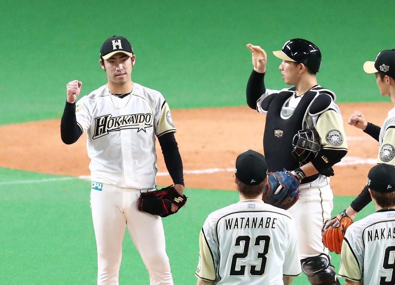 9回表、打者を3人で抑え選手を出迎える秋吉（左）（撮影・黒川智章）