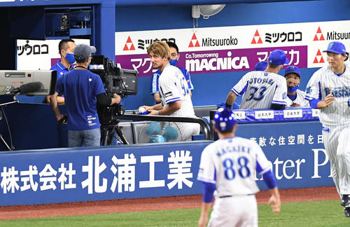 DeNA対阪神　4回に2点適時二塁打を放ったDeNA国吉（中央）は記念球をベンチの奥へ片付ける（撮影・山崎安昭）