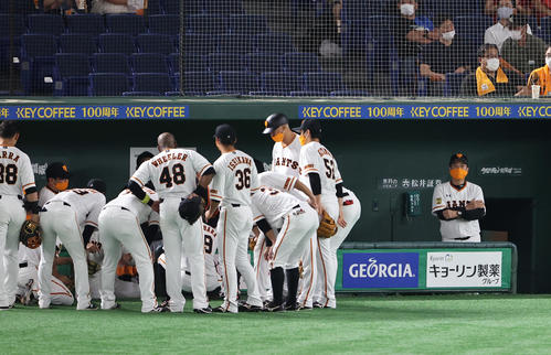 巨人対ヤクルト　3回裏巨人の攻撃前、円陣を組む選手の奥で腕組みし考える表情の原監督（右）（撮影・浅見桂子）