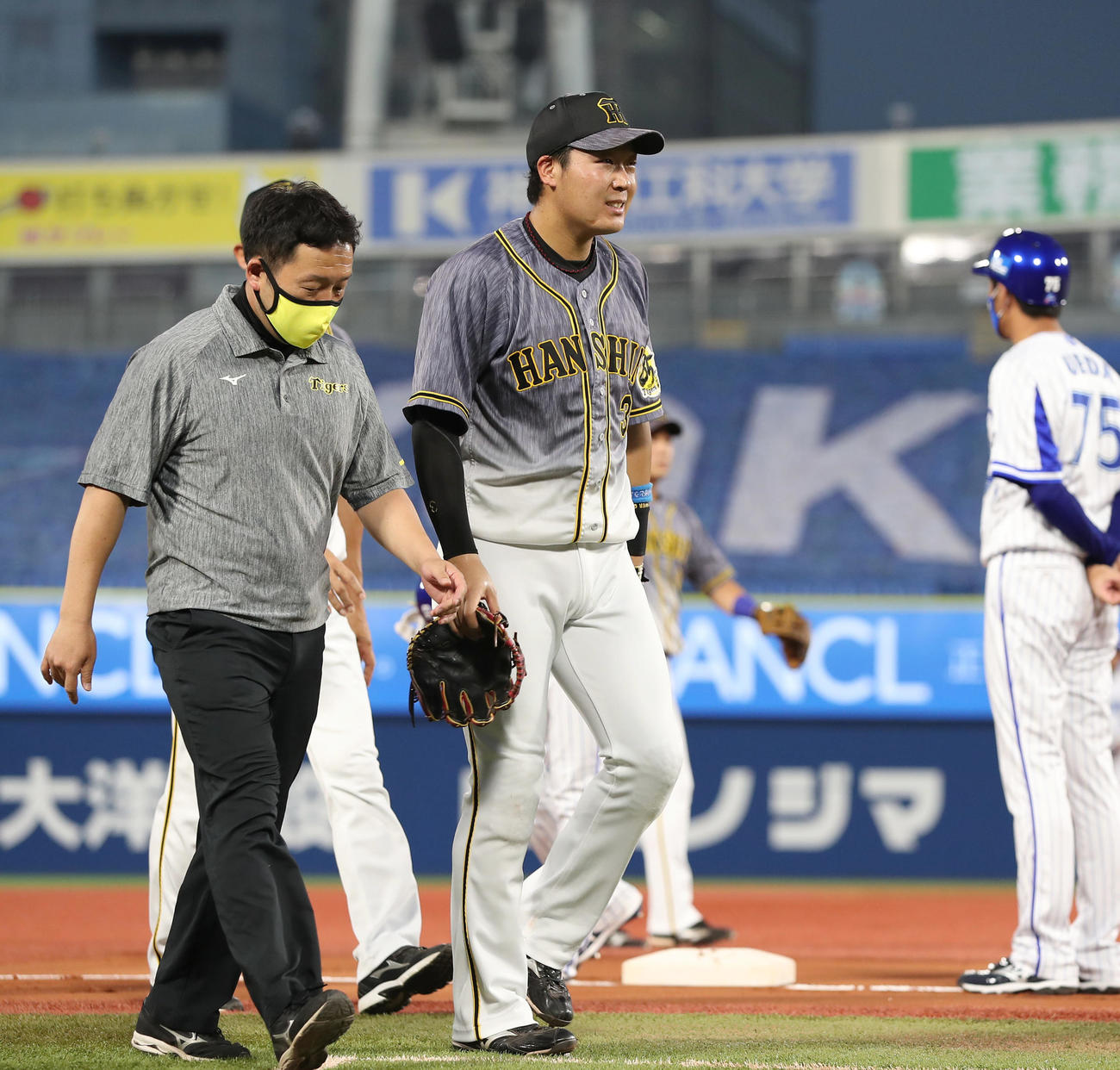 DeNA対阪神　1回裏DeNA1死一塁、宮崎が左翼線へ二塁打を放った直後、足を痛めた大山（中央）は治療のためベンチへ向かう（撮影・前田充）