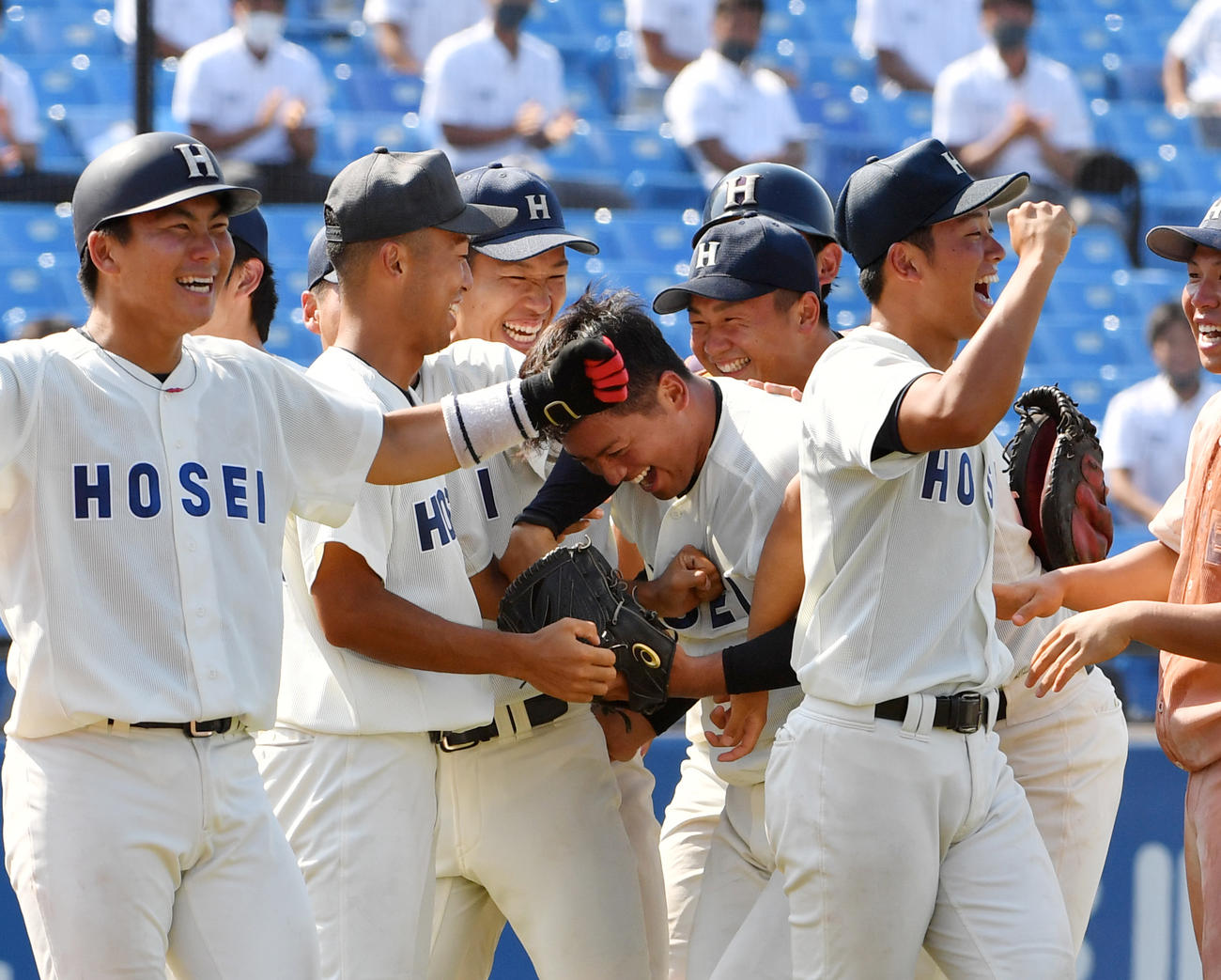 法大対明大　タイブレーク12回で勝利した法大・野尻（中央）はナインから頭をたたかれる（撮影・柴田隆二）