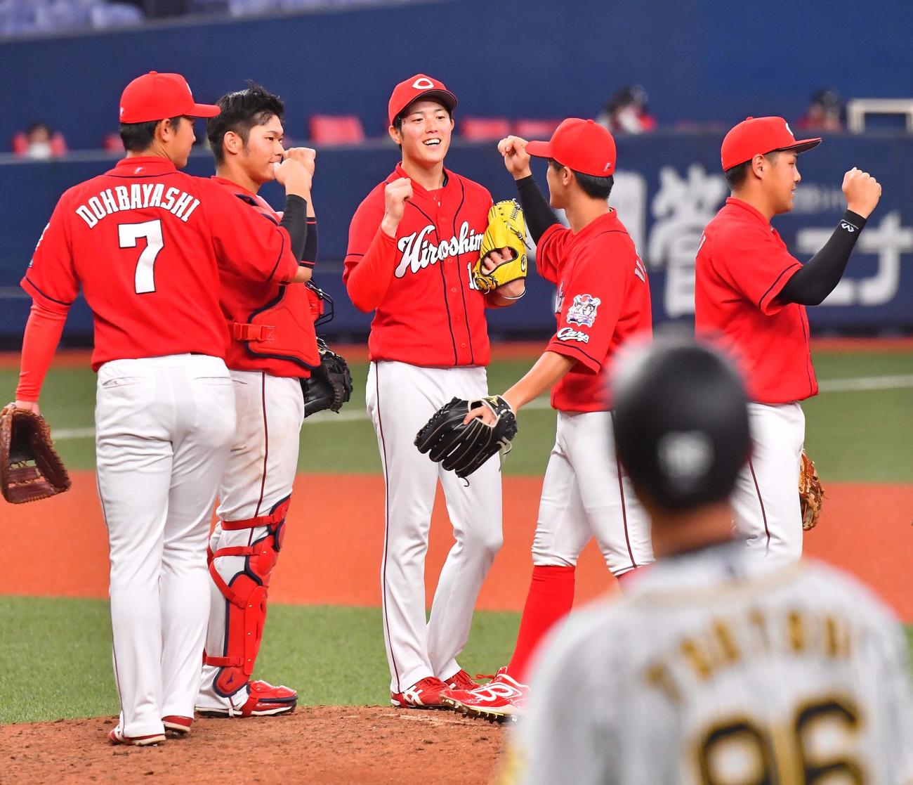 初完封勝利しナインとエアタッチで笑顔を見せる森下暢仁（中央）（撮影・上田博志）