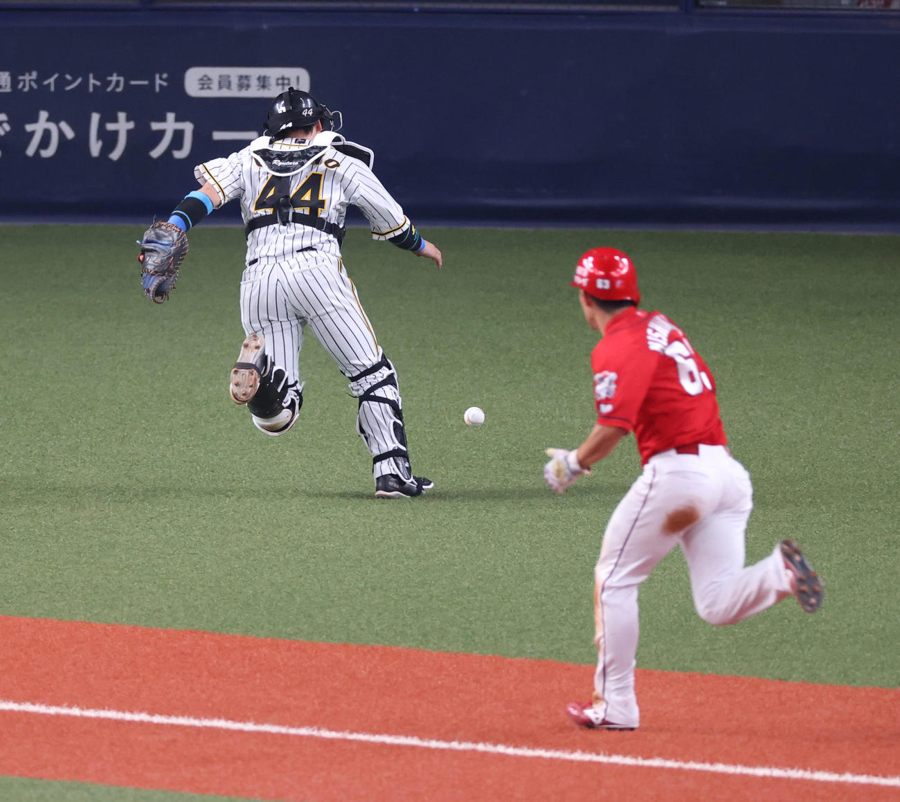 岩崎の暴投で捕手梅野が止めきれず三塁走者西川が同点のホームを踏む（撮影・清水貴仁）