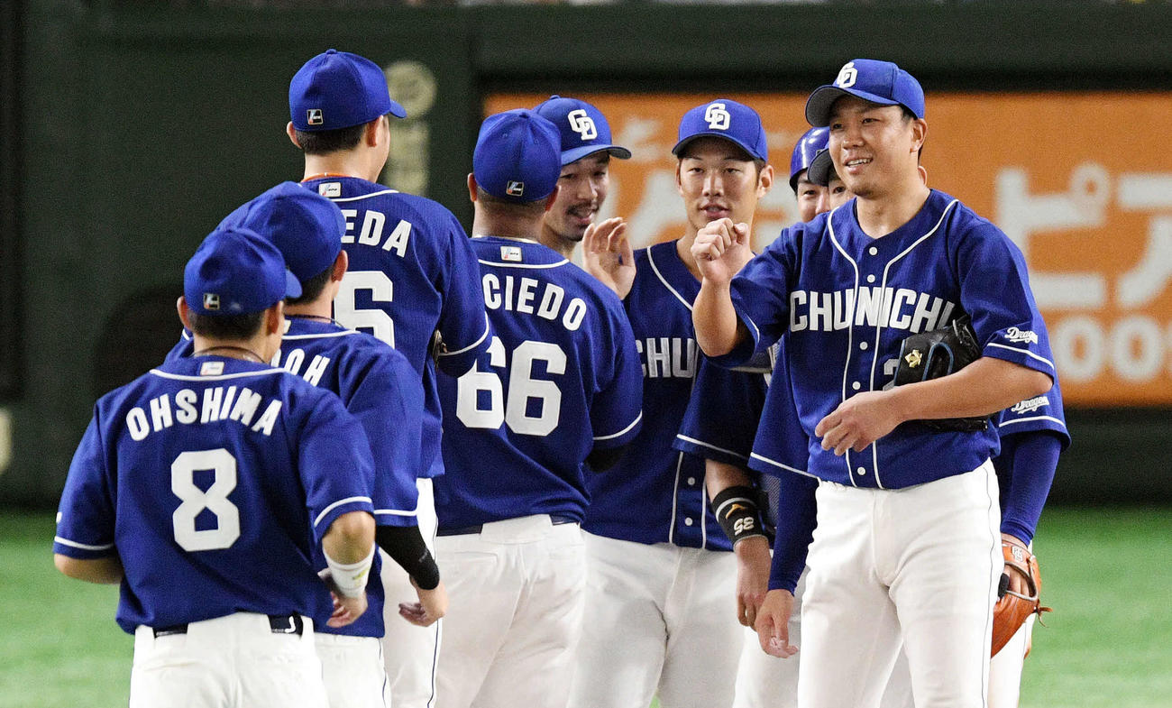 巨人対中日　完投勝利した中日大野雄（手前右）は笑顔でナインとグータッチを交わす（撮影・滝沢徹郎）