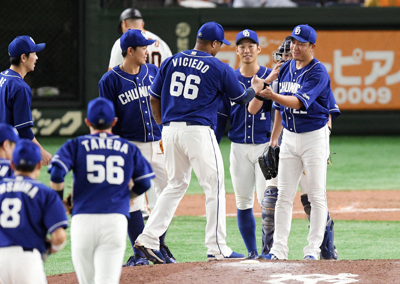 巨人対中日　完投勝利した中日大野雄（手前右）はビシエドから勝利球を受け取る（撮影・滝沢徹郎）
