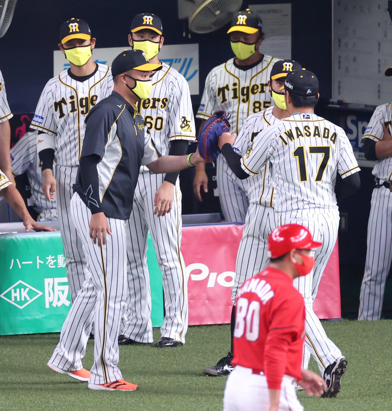 阪神対広島　10回の登板を終えた岩貞祐太をキャッチャーミットをはめ出迎える秋山拓（撮影・清水貴仁）
