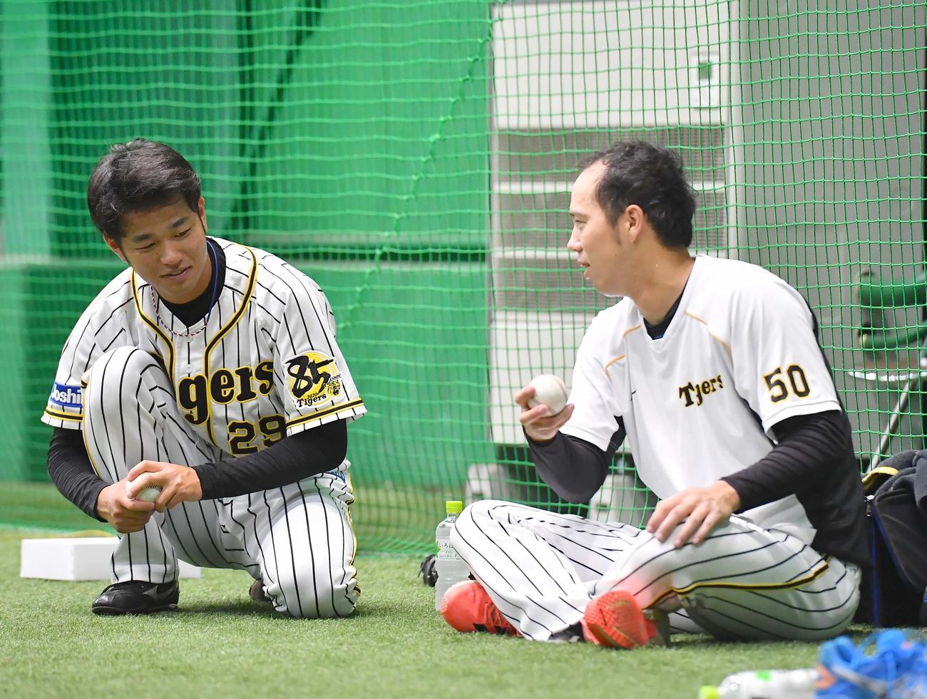 青柳（右）に変化球の握りを教えてもらう高橋（撮影・上田博志）