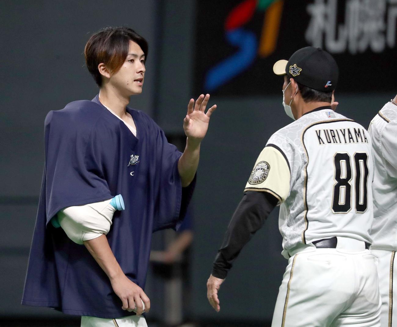 日本ハム対楽天　試合終了後、日本ハム栗山監督（右手前）に出迎えられる上沢（撮影・佐藤翔太）