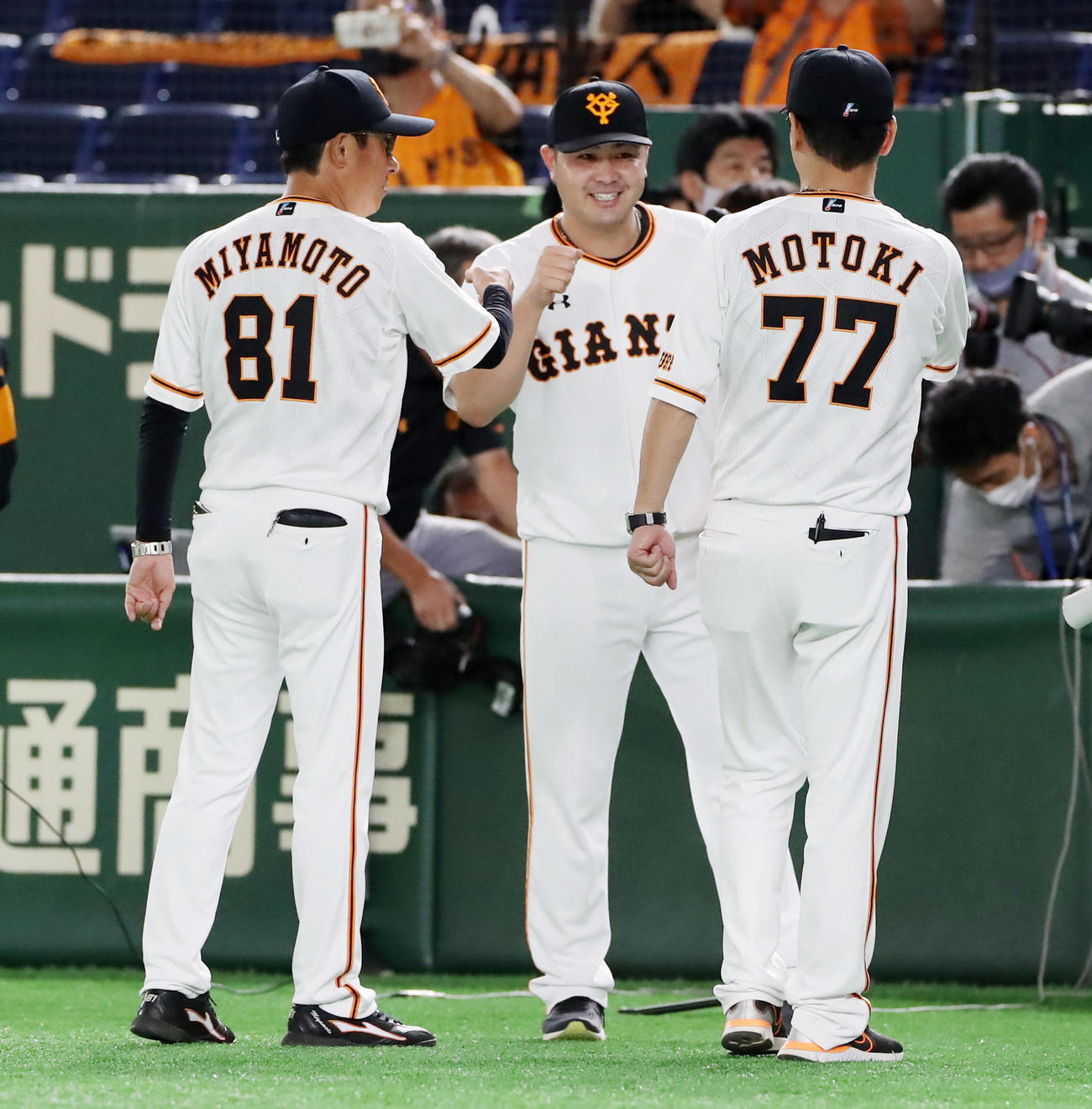 巨人対阪神　阪神に勝利し宮本コーチ（左）、元木コーチ（右）からエアタッチされ笑顔を見せる田中豊（撮影・加藤哉）
