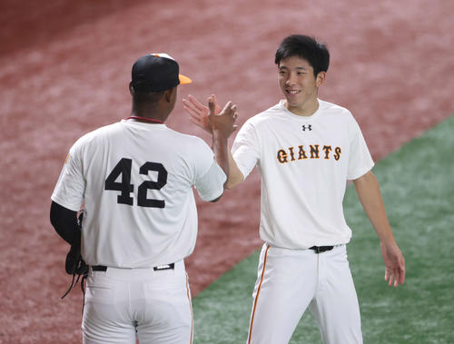 巨人対阪神　試合前練習を引き揚げる巨人メルセデス（左）を激励する戸郷（撮影・河野匠）