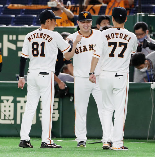 巨人対阪神　阪神に勝利し宮本コーチ（左）、元木コーチ（右）からエアタッチされ笑顔を見せる田中豊（撮影・加藤哉）