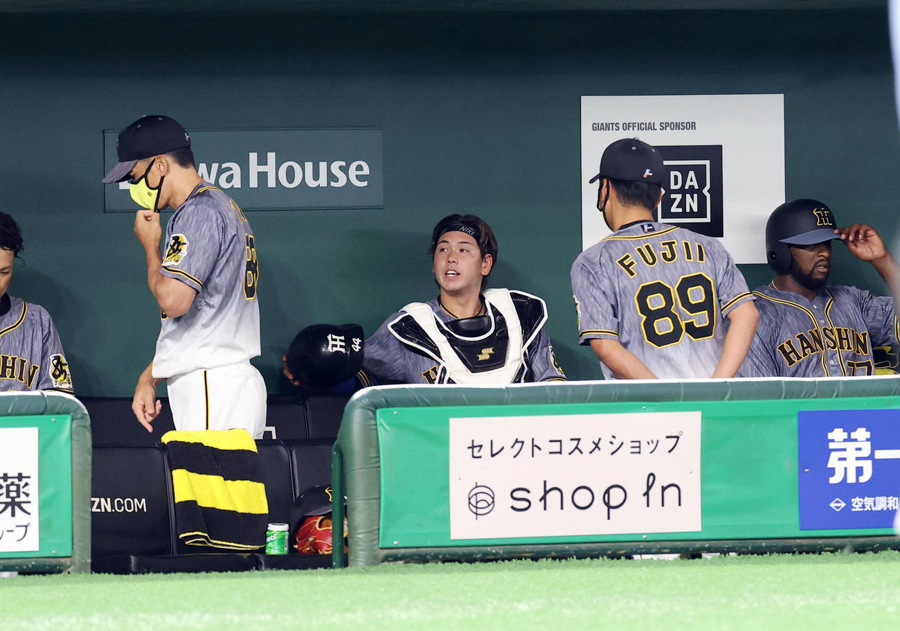 巨人対阪神　3回裏を終えベンチに戻った阪神梅野（右から3人目）に声をかけ席に戻る矢野監督（左）（撮影・垰建太）