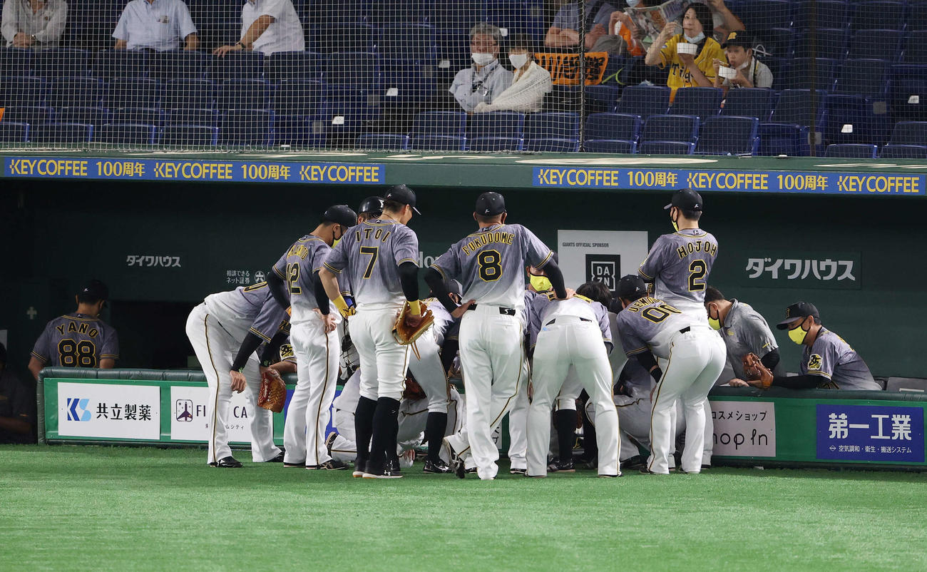 巨人対阪神　4回表を前に円陣を組む阪神ナイン。左端はベンチ裏に下がる矢野監督（撮影・河野匠）