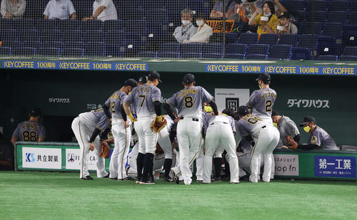 巨人対阪神　4回表を前に円陣を組む阪神ナイン。左端はベンチ裏に下がる矢野監督（撮影・河野匠）