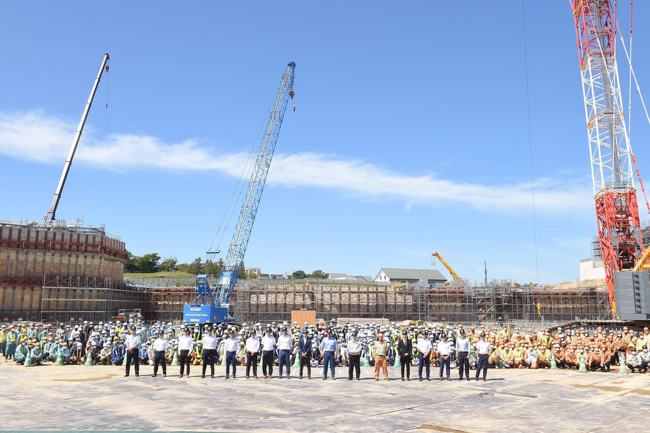 北海道・北広島にある新球場建設予定地を見学した日本ハムの選手・コーチ15人は約400人の作業員とともに記念撮影する