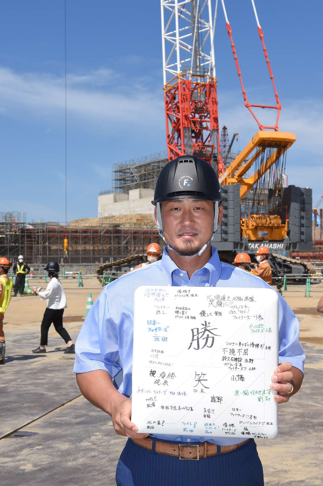 北海道・北広島にある新球場建設予定地を見学した日本ハム中田（右）は作業員から寄せ書きされたベースを受け取る
