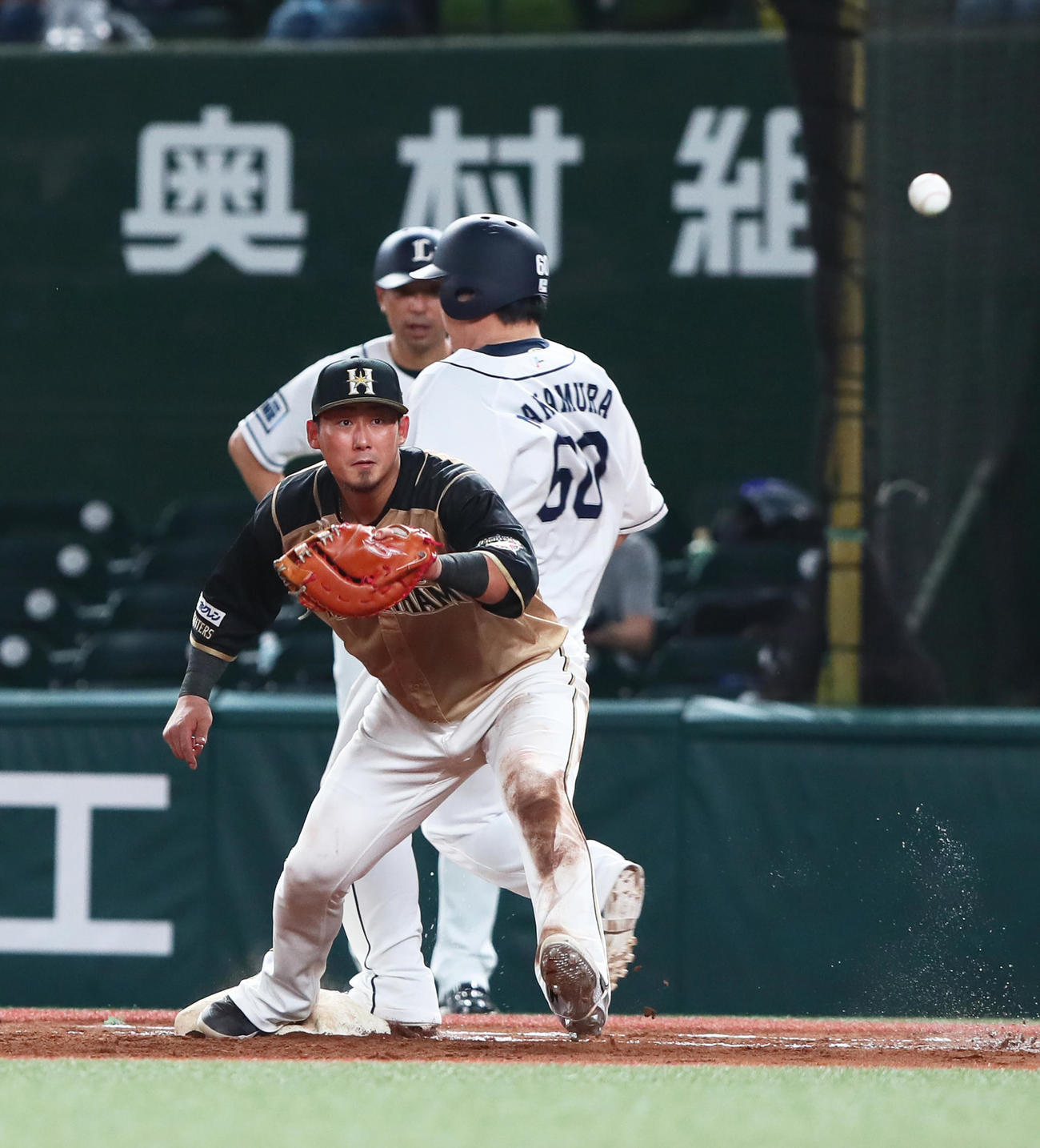 西武対日本ハム　5回裏西武無死、内野安打で通算1500安打を達成した中村（中央）。手前は日本ハム一塁手中田（撮影・足立雅史）