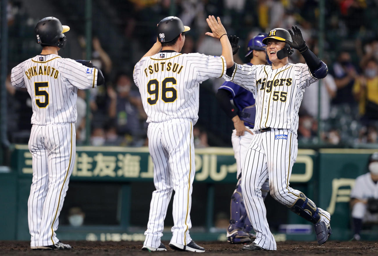 阪神対中日　6回裏阪神1死一、二塁、左中間へ逆転3点本塁打を放ち、笑顔で生還する陽川（右）。中央は迎える筒井コーチ、左は近本（撮影・前田充）