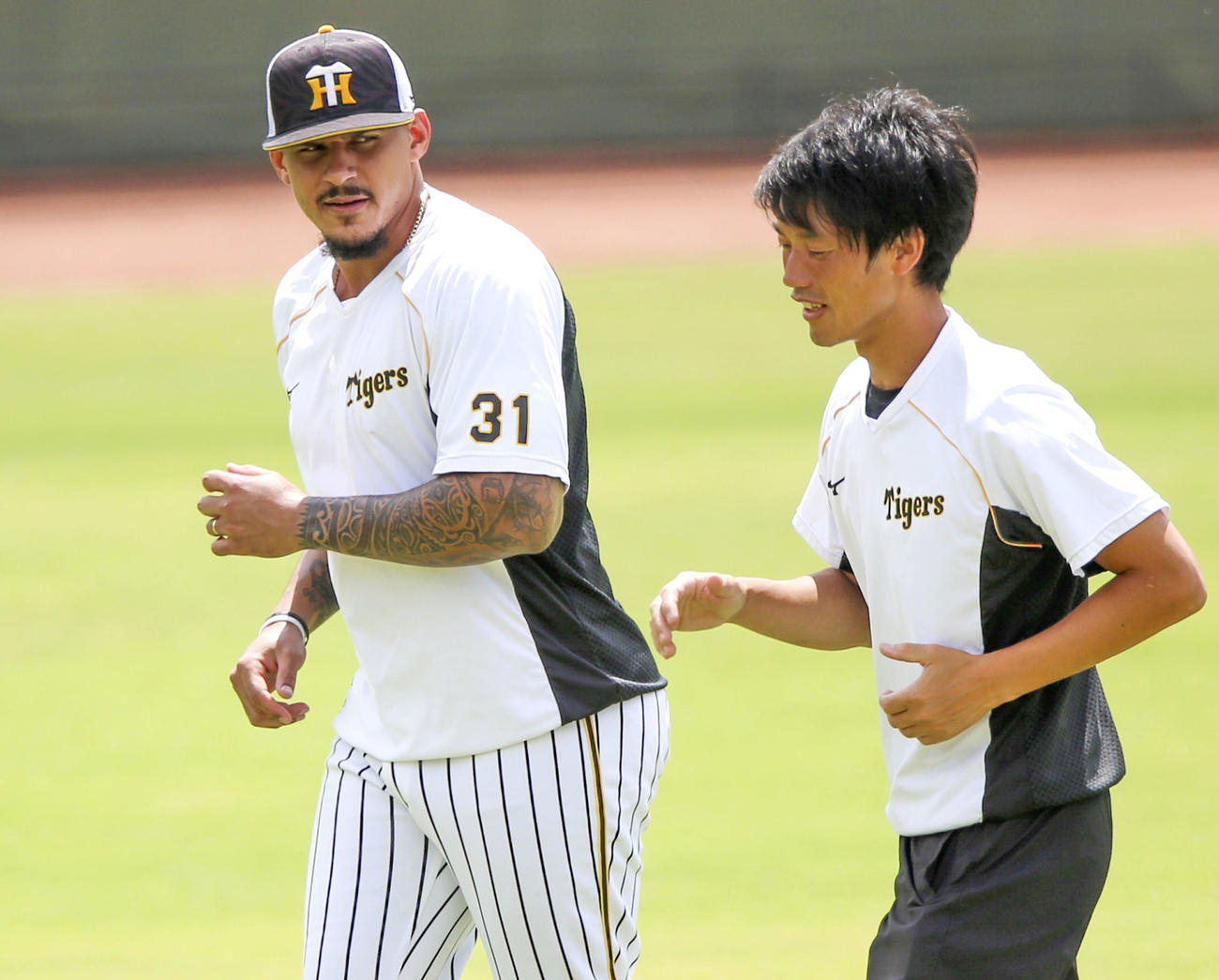 阪神マルテ（左）はスタッフと話しながらジョギングする（撮影・上山淳一）