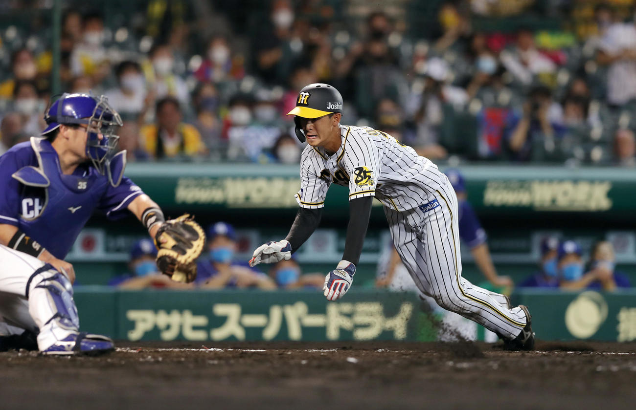 阪神対中日　5回裏阪神2死二塁、小幡は近本の適時打でヘッドスライディングで生還する（撮影・前田充）