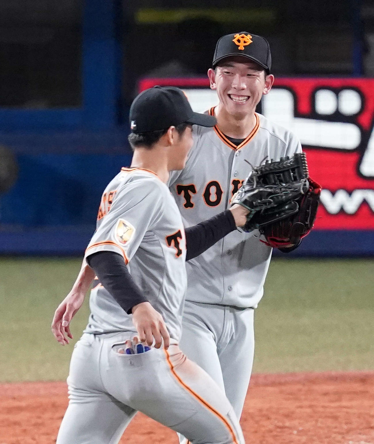 ヤクルト対巨人　4回裏終了後、巨人右翼手松原（左）を迎え笑顔を見せる戸郷（撮影・江口和貴）