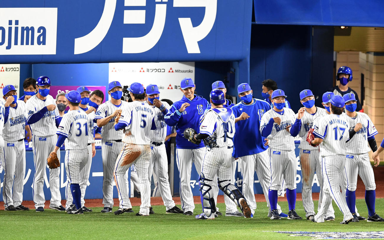DeNA対広島　笑顔でナインとタッチをかわすDeNA井納（中央）（撮影・横山健太）