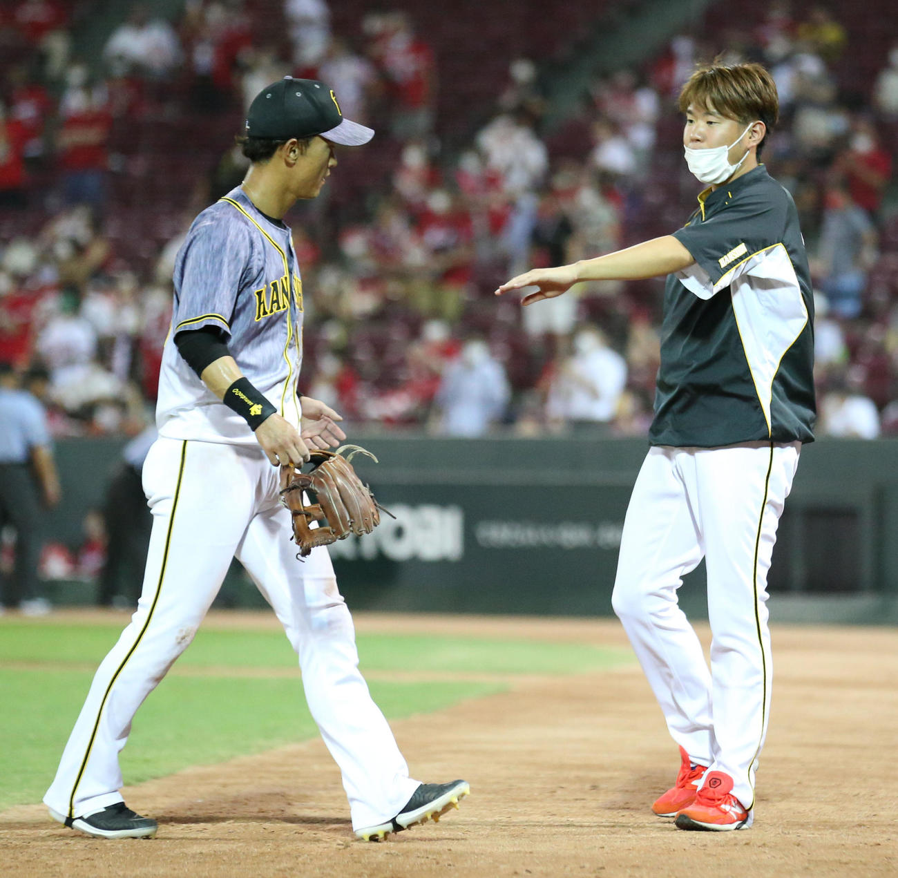 広島対阪神　サヨナラで広島に敗れ西勇（右）は引き揚げる上本をねぎらう（撮影・上山淳一）