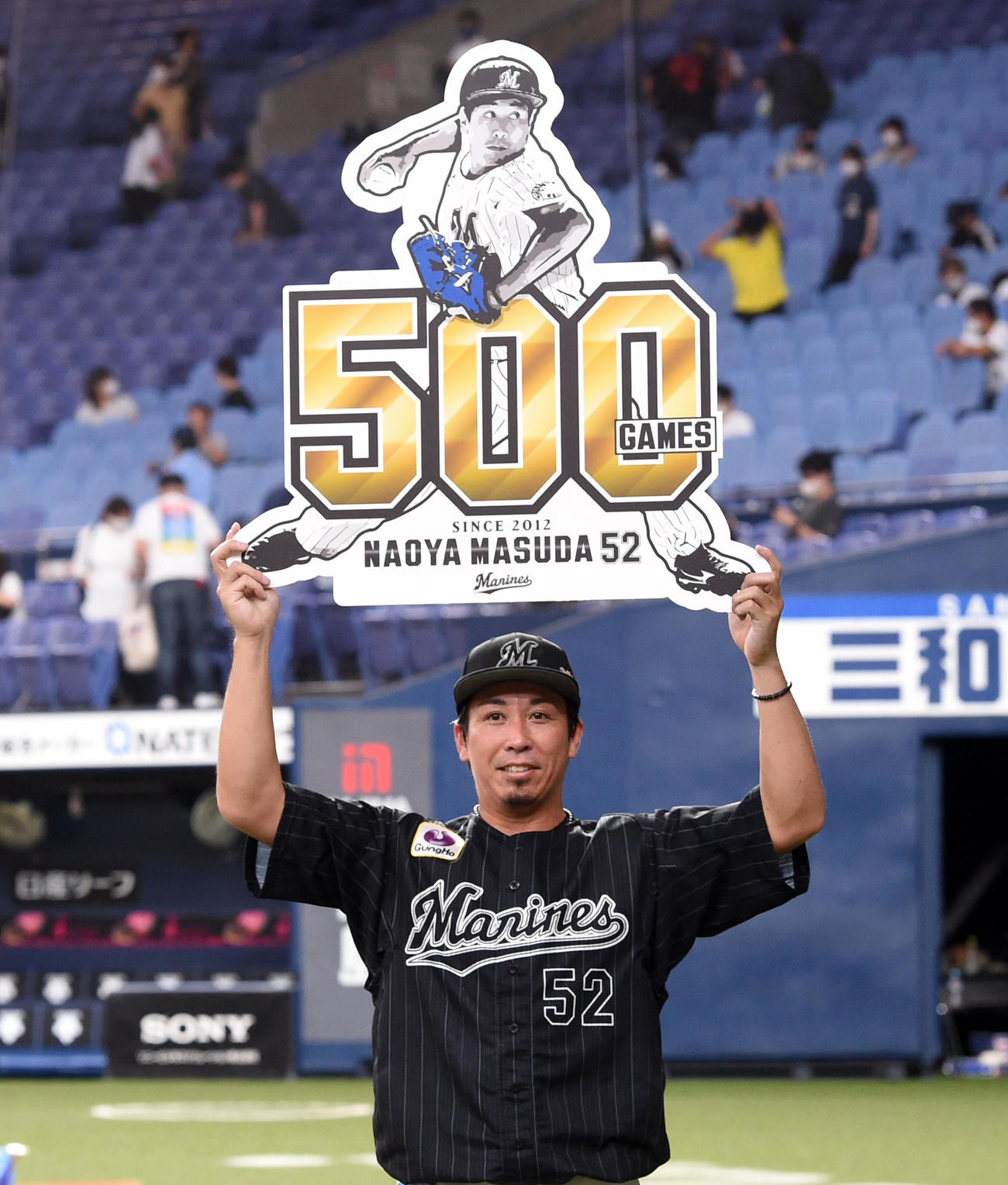 オリックス対ロッテ　500試合登板を達成、記念ボードを手に笑顔を見せる益田（撮影・前岡正明）