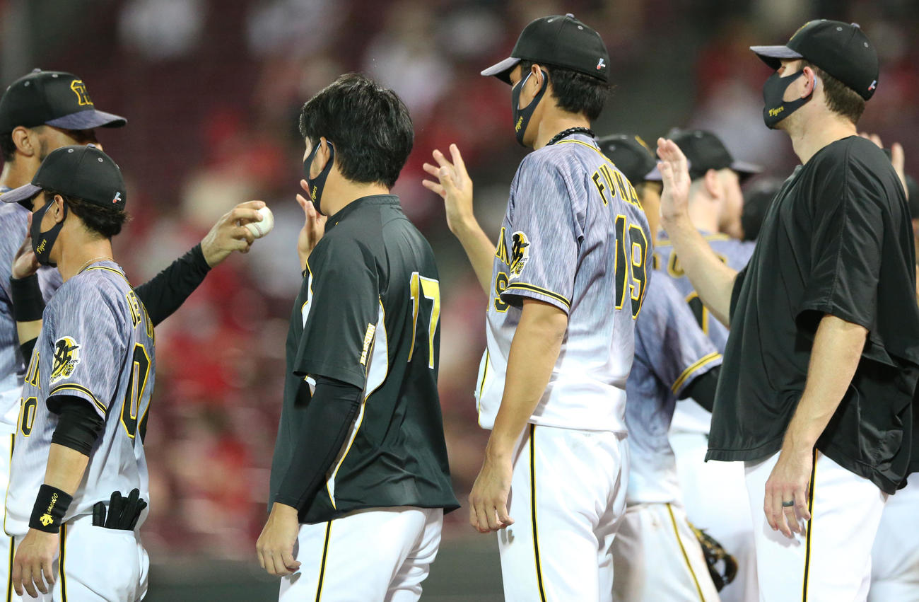 広島対阪神　広島に勝利し岩貞（左から3人目）はスアレスからウイニングボールを受け取る（撮影・上山淳一）