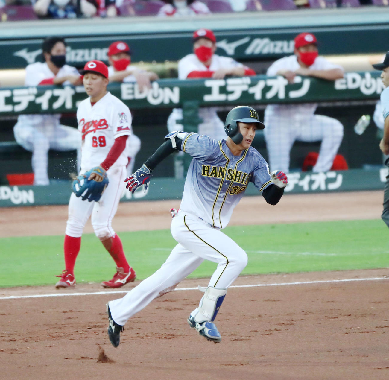 広島対阪神　2回表阪神1死一、三塁、一塁線へのバントを決めた小幡は、適時内野安打と悪送球で2点を奪い、自らも三塁に達する（撮影・加藤哉）