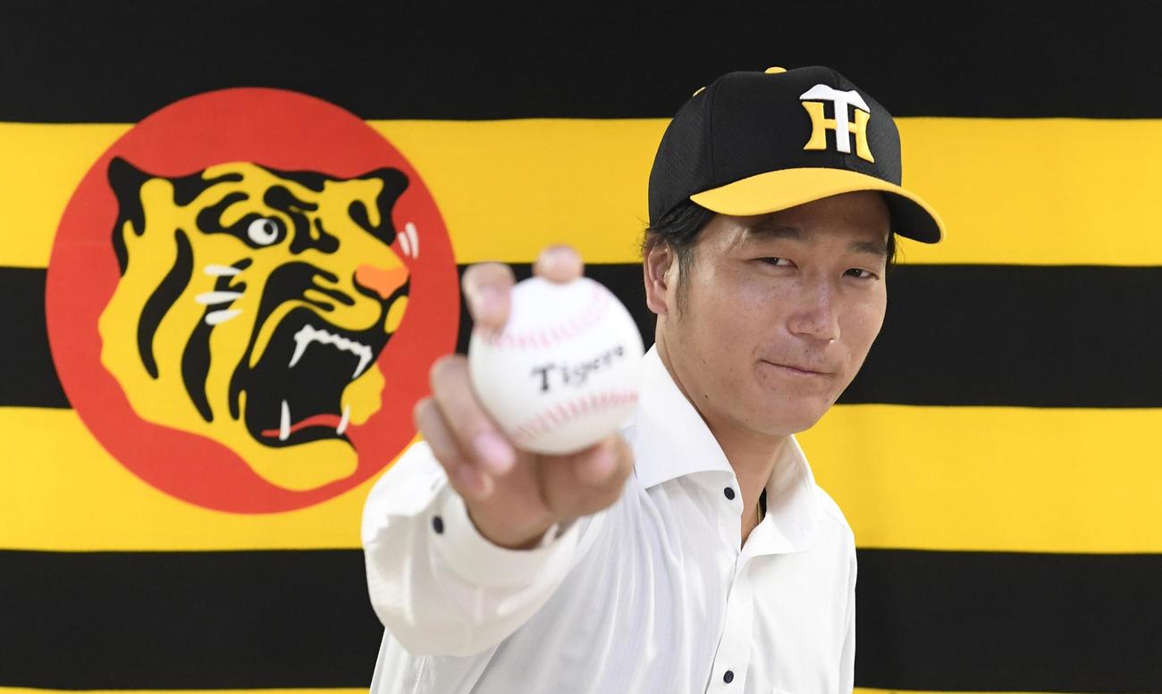 阪神への入団会見でポーズをとる小林慶祐