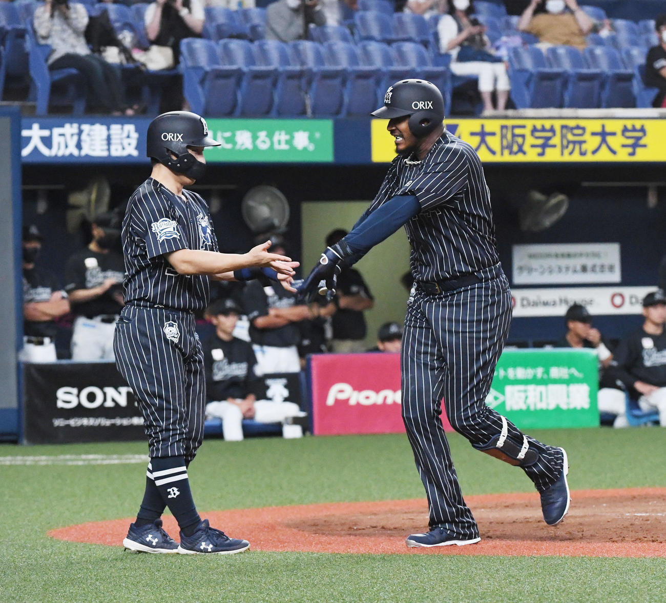 オリックス対ロッテ15回戦　5回裏オリックス2死一、二塁、アダム・ジョーンズ（右）は左中間に3点本塁打を放ち吉田正尚の祝福に笑顔を見せる（撮影・前岡正明）