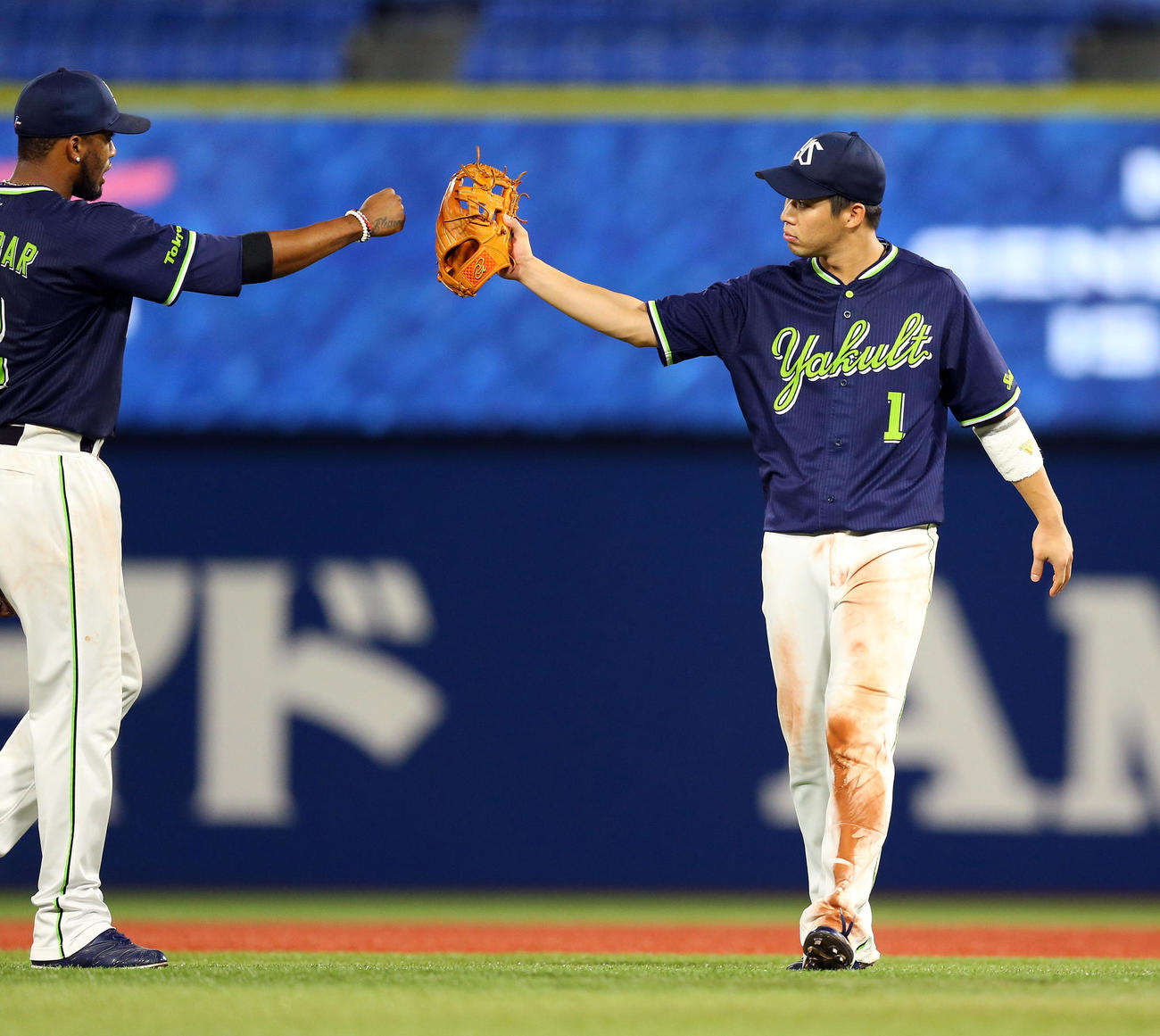 DeNA対ヤクルト　勝利し、ヤクルトのエスコバー（左）とグラブタッチする山田哲（撮影・大野祥一）