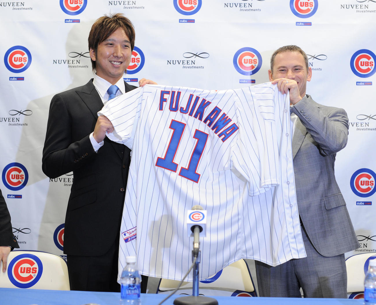 カブス入団会見で背番号11のユニホームを笑顔で手にする藤川球児。右はジェド・ホイヤーGM（2012年12月7日撮影）