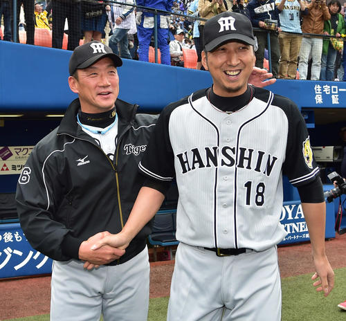 誕生日の金本知憲監督（左）に花を添える日本球界復帰星を挙げ笑顔で握手を交わす藤川球児（2016年4月3日撮影）