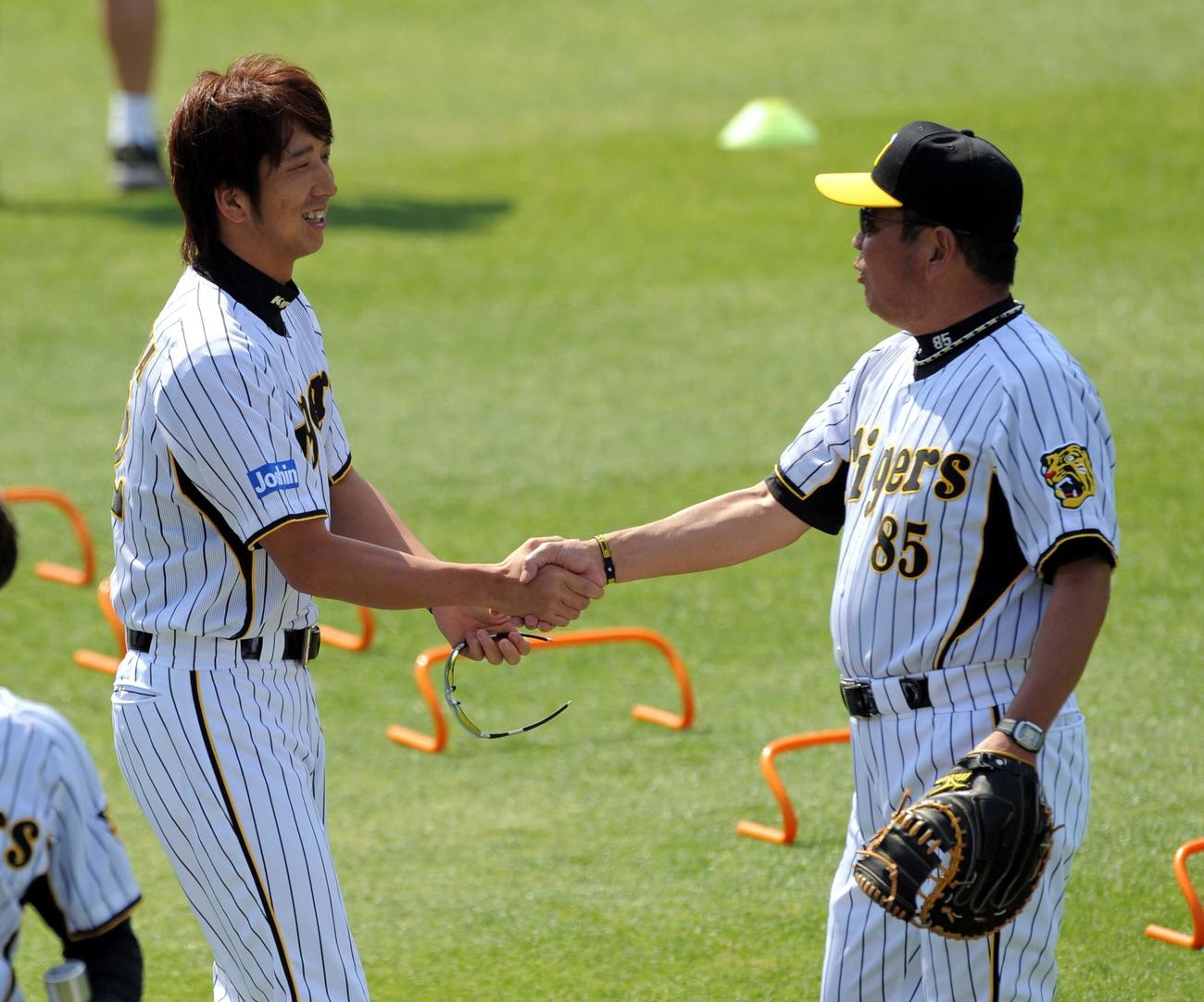 藤川球児は山口高志コーチ（右）と握手を交わし笑顔を見せる（2009年5月13日）