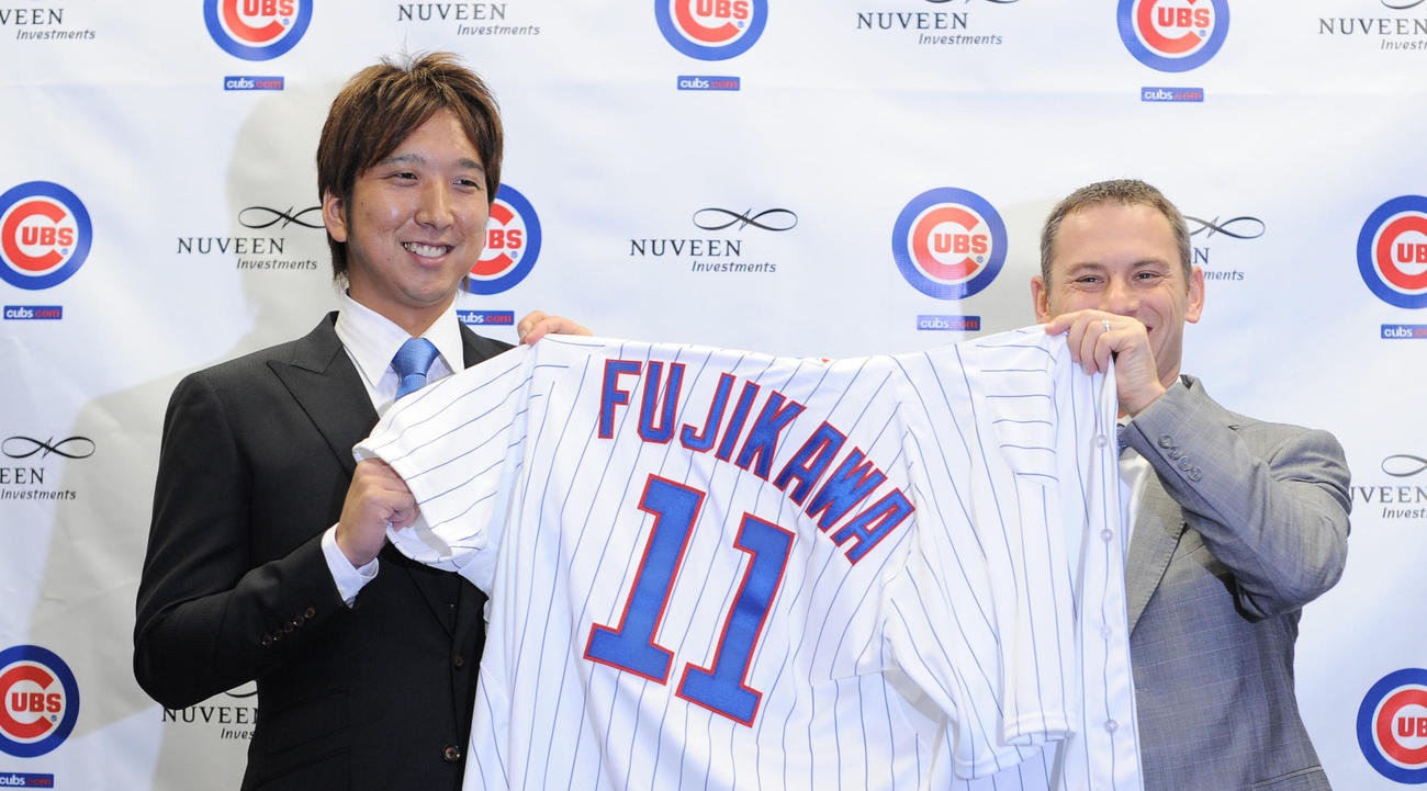 12年12月7日、カブス入団会見で背番号11のユニホームを手にする藤川。右はジェド・ホイヤーGM