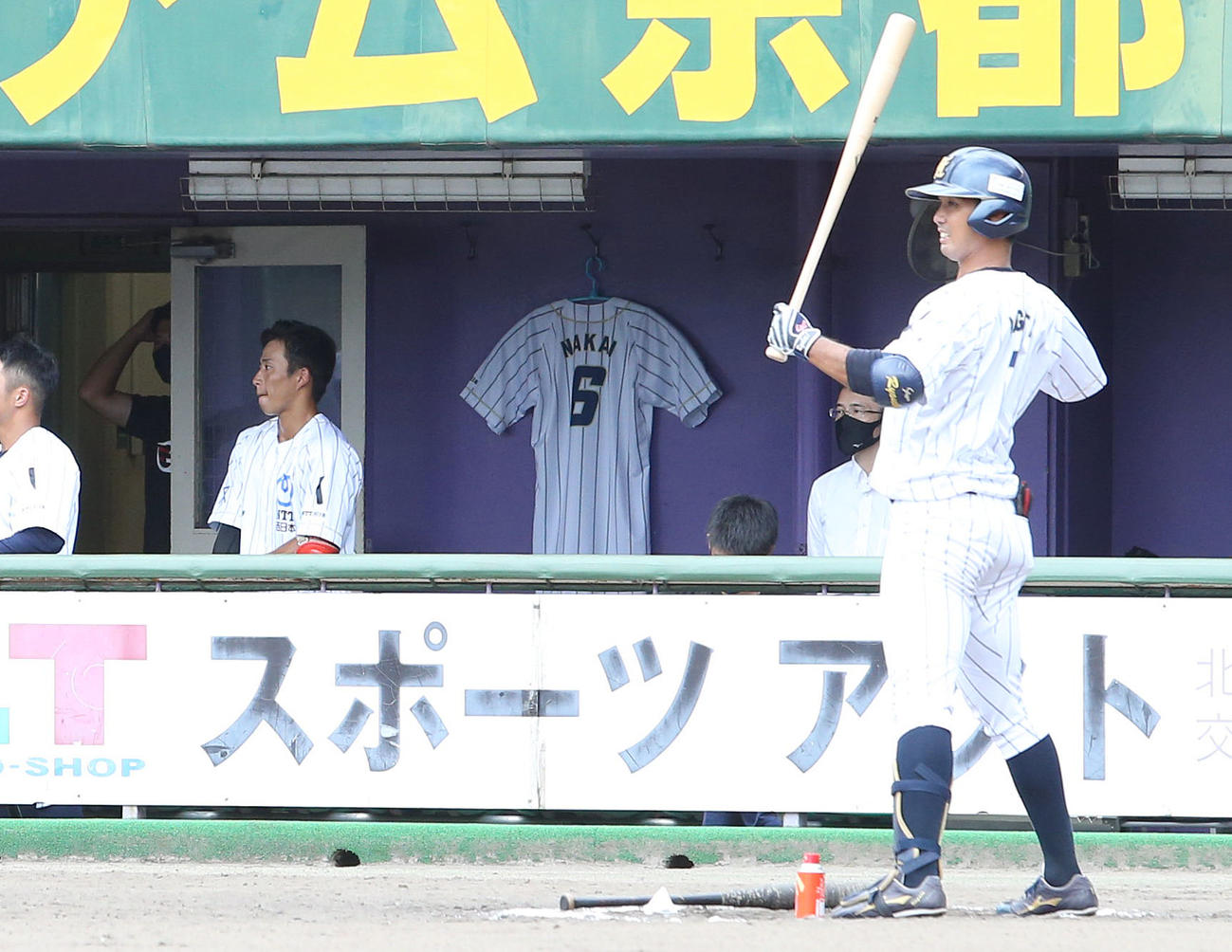 4月に亡くなった中井諒さんのユニホームが掲げられたNTT西日本ベンチ（撮影・白石智彦）