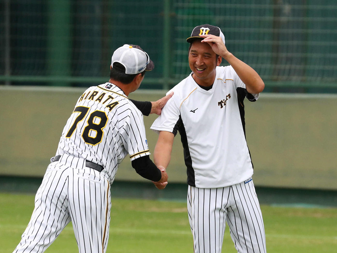 選手の前でのあいさつ後、平田2軍監督（左）からねぎらいを受ける藤川