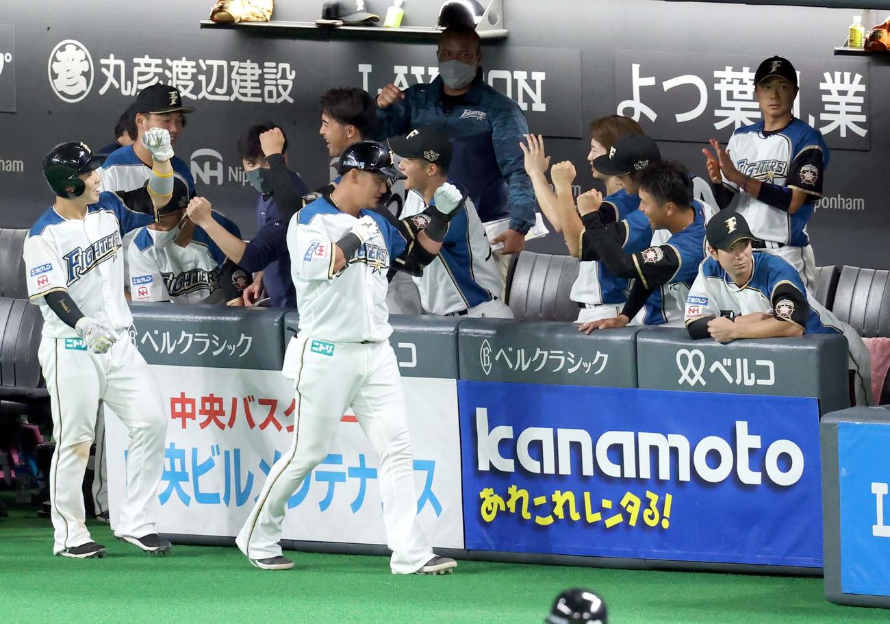 日本ハム対楽天　5回裏日本ハム1死一塁、中越え2点本塁打を放ちチームメートに出迎えられる中田（中央）（撮影・佐藤翔太）