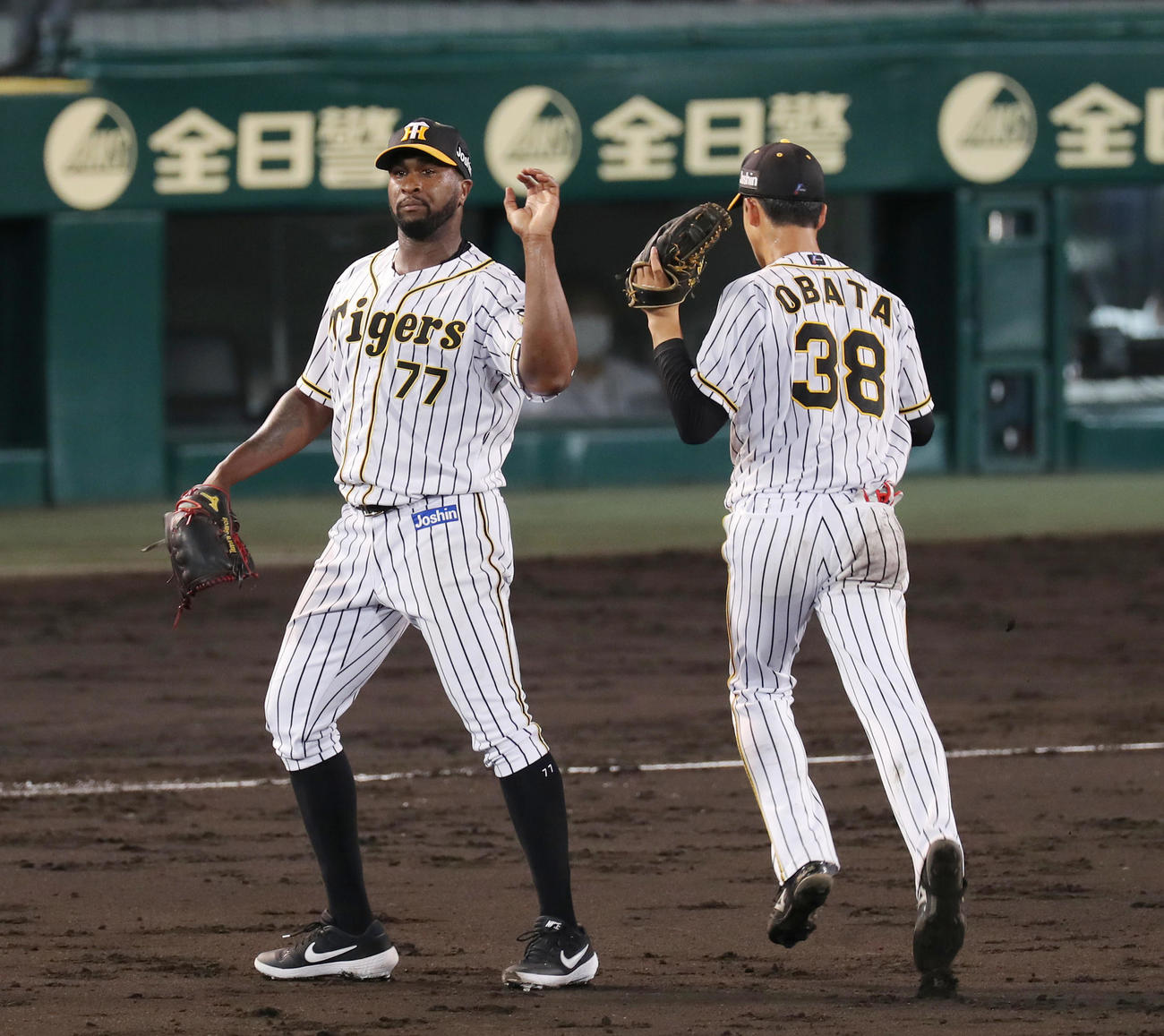 阪神対ヤクルト　5回表ヤクルト2死、山田哲の打球で好守を見せた二塁手小幡（右）をタッチで迎えるガルシア（撮影・前田充）