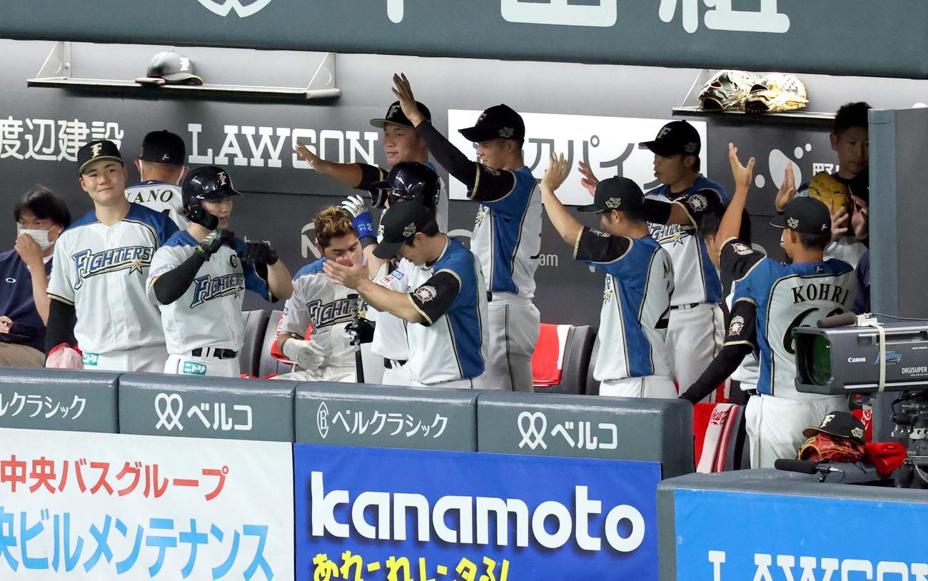 日本ハム対楽天　1回裏日本ハム1死二塁、中田の適時打で生還しチームメートに出迎えられる西川（左から2人目）（撮影・佐藤翔太）
