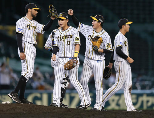 阪神対巨人　最後を締めたスアレス（左）とタッチする大山。中央は木浪、右端は小幡（撮影・上山淳一）
